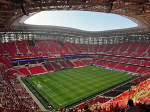Camarotes vazios na Copa do Mundo com voluntários ocupando os espaços.